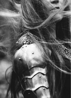 black and white photograph of a woman in armor with her hair blowing in the wind