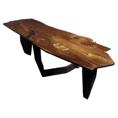 a wooden table with black metal legs and a wood slab on the top that is shaped like a boat