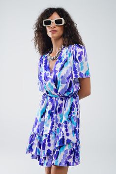 Introducing our Wrap Short Dress in Blue and Purple Tie-Dye, a vibrant and stylish addition to your summer wardrobe. This lovely short dress features a super flattering wrap design with a matching belt, creating a tailored fit that accentuates your waist. The ruffle at the hem adds a playful touch, while the eye-catching blue and purple tie-dye pattern ensures you stand out in any crowd.  Crafted from 100% Polyester, the dress offers a lightweight and comfortable wear, perfect for warm weather. Blue V-neck Mini Dress With Tie Waist, Spring Blue Wrap Dress With Surplice Neckline, Blue Wrap Dress With Surplice Neckline For Summer, Blue V-neck Wrap Dress For Beach, Blue V-neck Wrap Dress For The Beach, Summer Wrap Mini Dress With Tie Waist, Blue Wrap Dress With Surplice Neckline For Beach, Blue Surplice Neckline Wrap Dress For Beach, Blue V-neck Wrap Dress With Tie Waist