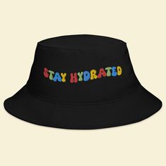 Keep the festival spirit alive with our "Stay Hydrated" Bucket Hat. This hat isn't just an accessory; it's a reminder to take care of yourself and spread positive vibes while you groove to the beats of EDM, Rave, and your favorite music festivals. 🎵 Key Features 🎵 Premium quality fabric for all-day comfort Unique design that promotes staying hydrated and positive vibes Trendy bucket hat style that adds flair to your festival attire One size fits most for convenient wear 🌈 Festival Vibes 🌈 Wh Affordable Cap For Music Festival, Adjustable Flat Brim Sun Hat For Streetwear, Fun Adjustable Hats For Streetwear, Fun Adjustable Streetwear Hats, Retro Adjustable Hats For Festivals, Casual Black Bucket Hat For Festivals, Adjustable Fun Hat For Streetwear, Trendy Adjustable Hats For Music Festival, Black Fun Bucket Hat For Summer