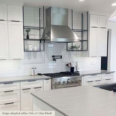 a white kitchen with stainless steel appliances and marble counter tops is pictured in this image