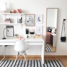 a white desk and chair in a room with pictures on the wall above it,