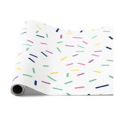 a white wrapping paper with colorful sprinkles on the bottom and one side