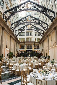 the inside of a large building with tables and chairs set up for an event in it