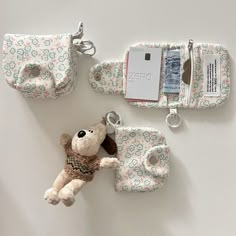 a stuffed animal keychain, wallet and cell phone case on a white surface