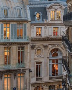 an old building with many windows and balconies on the top floor is lit up at night