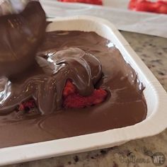 someone is spreading chocolate on top of strawberries