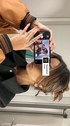 a woman taking a selfie with her cell phone in front of her face,