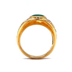 a gold ring with a green stone and diamonds on the side, against a white background