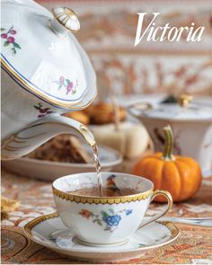 a tea cup filled with liquid being poured into it