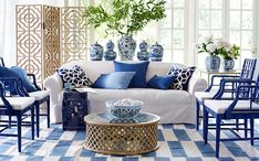 a living room filled with furniture and blue and white decor on top of a checkered floor