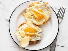 two pieces of toast with an egg on top and butter drizzled over them