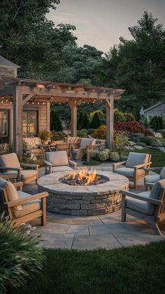 an outdoor fire pit surrounded by chairs and tables with lights on it's sides