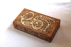 an intricately carved wooden box on a white surface with the word love written in it