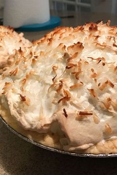 there is a pie with coconut on it sitting on the counter top, ready to be eaten