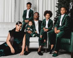 a group of people sitting on top of a couch in front of a christmas tree