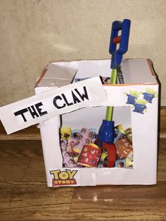 an open box with toys in it and the word the claw stuck to it's side