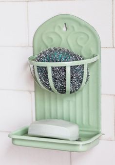 a green bathroom shelf with a toilet paper holder on it