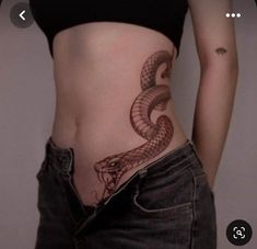 a woman's stomach with a snake tattoo on her belly and the bottom part of her stomach