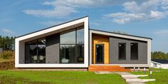 a modern house sits in the middle of a grassy field