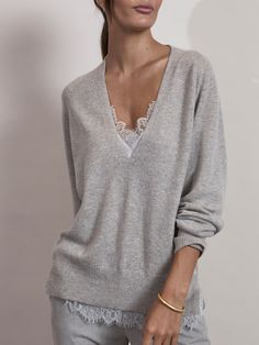 The Lace v-neck layered sweater is pre-styled with a cami underneath, revealing lace at the neck and bottom hem. A side split hem adds for an easy fit.