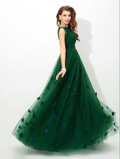 a woman in a green dress posing for the camera