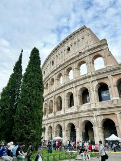 people are standing in front of the colossion, which is one of the most famous buildings in europe