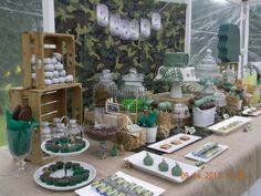 a table topped with lots of desserts covered in green frosting and cupcakes