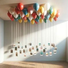 a bunch of balloons are hanging from the ceiling in an empty room with wooden floors