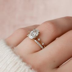 a woman's hand with a diamond ring on it