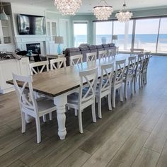 a dining room table and chairs with the ocean in the background