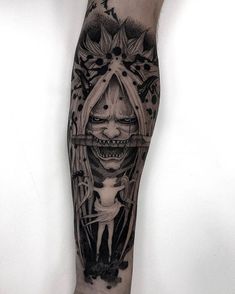 a man's leg with a black and grey tattoo design on it, featuring an image of a woman