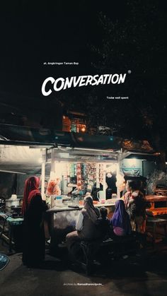 an advertisement for conversation on the side of a building at night with people sitting outside