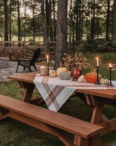 a picnic table with candles and pumpkins on it