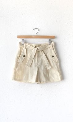 Embroidered, tailored shorts in a beige shade. Features a tie belt and front pockets with faux flap closures. Breathable material made perfect for the summer and spring weather. Pairs well with tank tops or loose blouses. Trouser pants Embroidered Tie belt Front welt pockets Back pockets Zipper closure Inseam: 3 1/2" Front rise: 11 3/8" Waist: 13 3/8" Hips: 22" Self: 100% Rayon Hand wash cold. Dry flat. Low iron, or dry clean Model is wearing a size small Style #: G222P6226 Spring Collection Fashion, Embroidered Tie, Luxury Women Fashion, Tailored Shorts, Twill Shorts, Feminine Design, Spring Weather, Loose Blouse, Linen Shorts