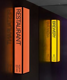 three books are sitting on the wall next to each other, one is yellow and the other is red