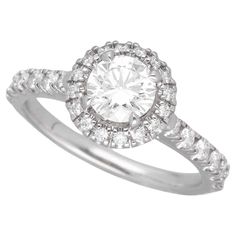 a white gold ring with an oval cut diamond surrounded by small round diamonds on the band