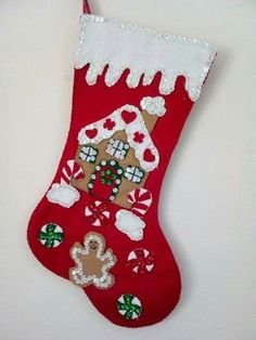 a red christmas stocking with gingerbreads, cookies and a house on it