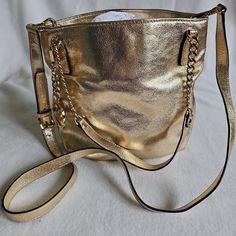 Never Used. Perfect For Holdiays Coming Up! Inside Has 1 Zipper Pocket And 4 Open Pockets Had Crossbody Strap And 2 Shoulder Straps Length 9.5" Width 2" Height 11" Gold Bucket Bag With Metal Hardware For Everyday Use, Gold Leather Bucket Bag With Metal Hardware, Gold Bucket Shoulder Bag With Adjustable Strap, Everyday Gold Bucket Bag, Gold Bucket Bag With Adjustable Strap For Evening, Gold Crossbody Bucket Bag For Shopping, Evening Gold Bucket Bag With Adjustable Strap, Gold Bucket Bag With Metal Hardware, Gold Shoulder Bag With Metal Hardware For Shopping