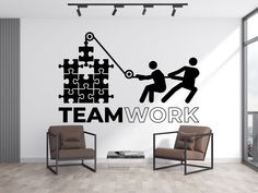 a wall decal with the words team work and two people pulling jigs together