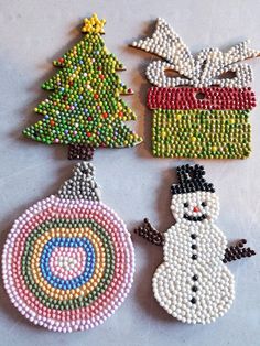 three beaded christmas ornaments on a table