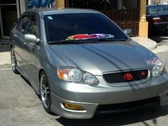 a silver car is parked in front of a building with graffiti on the windows and door