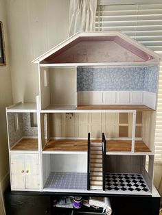 a doll house is shown with all the furniture and accessories on it's stand