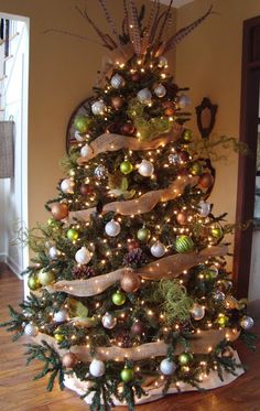 a decorated christmas tree in a living room with lights and ornaments on the bottom tier