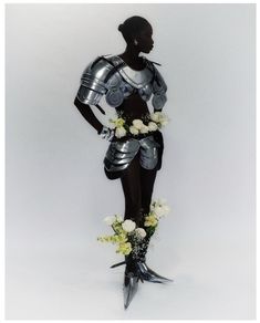 a woman dressed in armor and holding flowers