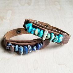 two leather bracelets with beads on them