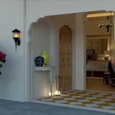 an entrance to a house with vases and flowers on the table