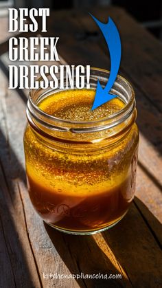 a mason jar filled with liquid sitting on top of a wooden table next to the words best greek dressing