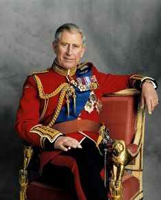 an older man in a red uniform sitting on a gold chair with his arms crossed