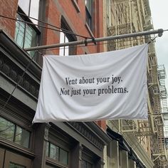 a sign hanging from the side of a building that says, ventt about your joy not just your problems